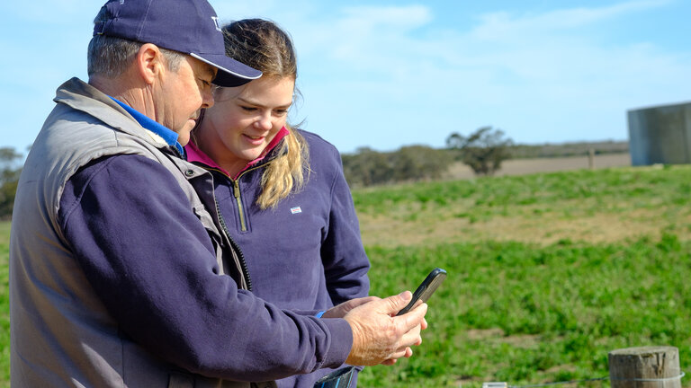 Two people monitoring a fence
